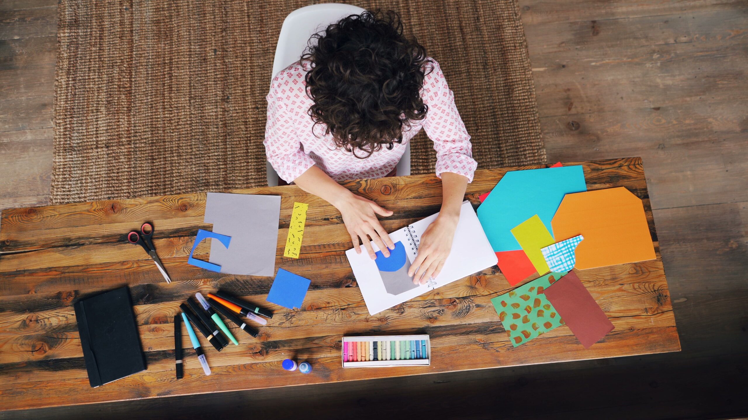 Vue d’en haut : une artiste compose un collage de papiers colorés
