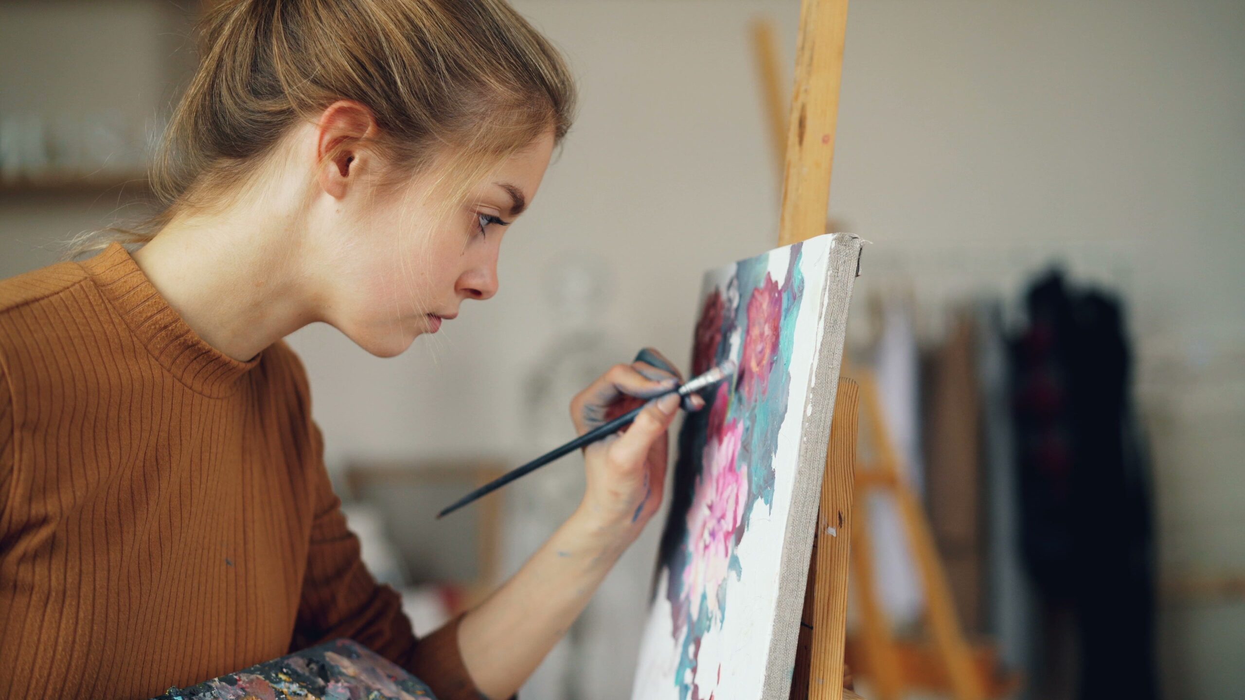 Artiste peignant des fleurs sur une toile, à son chevalet